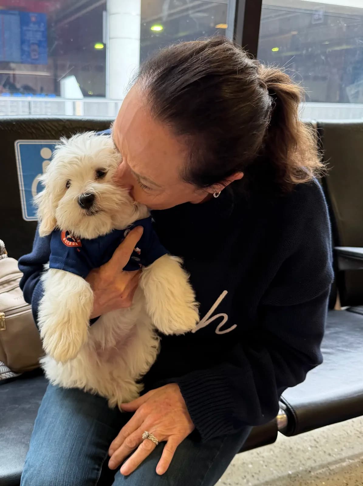 Deana kissing a Hope Cotons puppy goodbye at the airport before it flies home